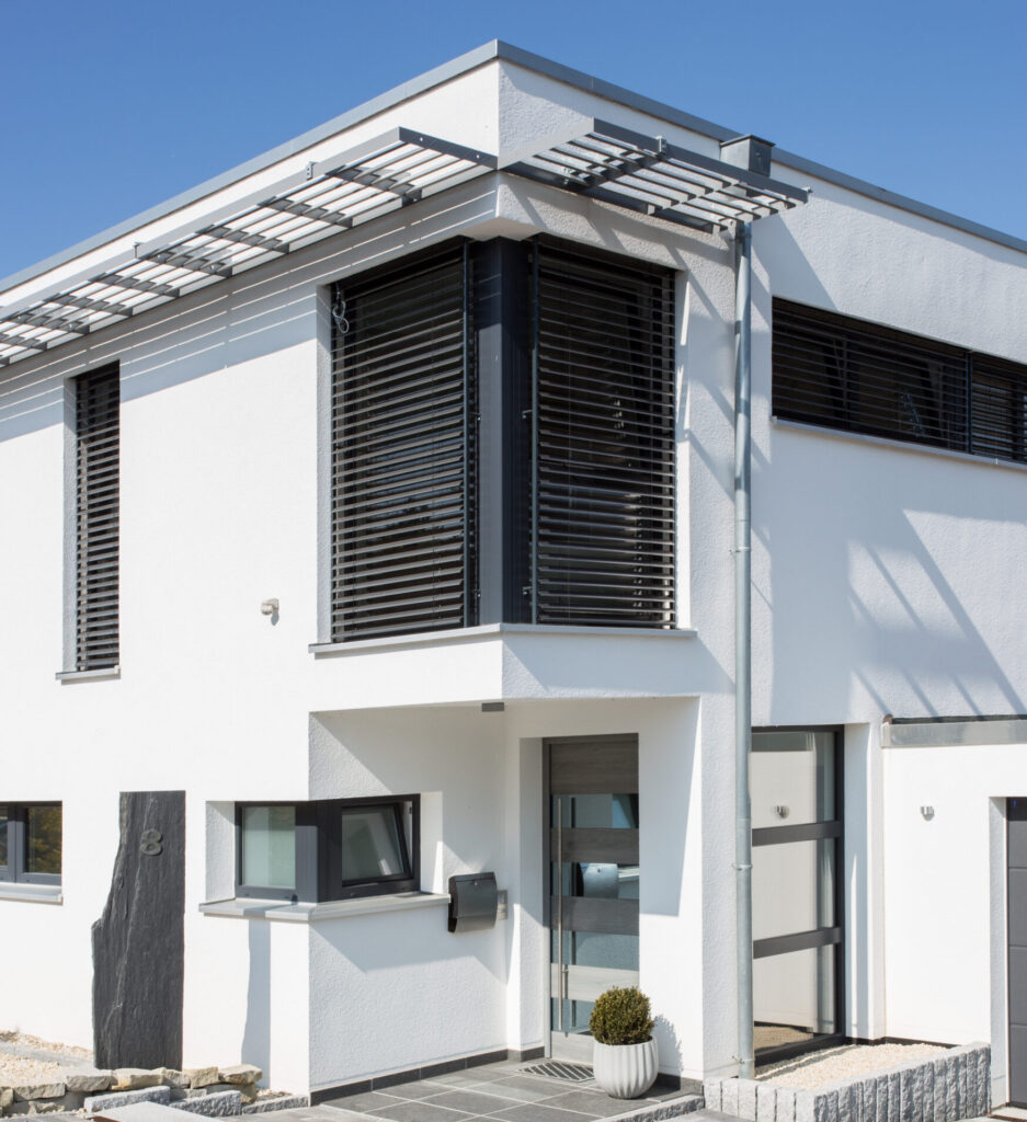 Das Bild zeigt ein modernes Einfamilienhaus mit einem Raffstore Beschattungssystem. PAGA GmbH Dortmund